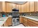 Well-equipped kitchen featuring light wood cabinets, stainless steel appliances, and tiled backsplash at 13221 Fountainbleau Dr, Clermont, FL 34711