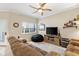 Cozy living room featuring a plush sofa, ceiling fan, and view of the front yard at 13221 Fountainbleau Dr, Clermont, FL 34711