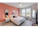 Stylish bedroom with a coral accent wall, chic decor, and ample natural light at 14031 Centerline Dr, Orlando, FL 32827