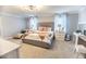 Bright bedroom boasts a comfortable bed, vanity, and sitting area with ample natural light and decor at 14664 Spotted Sandpiper Blvd, Winter Garden, FL 34787