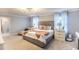 Spacious bedroom features a neutral palette, tufted headboard, and sitting area with lots of natural light at 14664 Spotted Sandpiper Blvd, Winter Garden, FL 34787