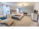 Spacious main bedroom with a large bed, chaise lounge, a dresser and plenty of natural light at 14664 Spotted Sandpiper Blvd, Winter Garden, FL 34787