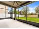 A screened porch featuring a view of a well-maintained lawn and white vinyl fence at 14664 Spotted Sandpiper Blvd, Winter Garden, FL 34787