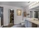 Bright bathroom featuring a vessel sink, with an open doorway to a walk-in closet, and glass shower at 1602 Pine Ridge Dr, Davenport, FL 33896