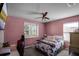 Cozy bedroom featuring windows, a ceiling fan and carpeting at 1602 Pine Ridge Dr, Davenport, FL 33896