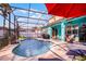 Inviting screened pool area featuring an umbrella, lounge chairs, and space for entertaining at 1602 Pine Ridge Dr, Davenport, FL 33896