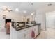 Kitchen island features granite countertops, a stainless steel sink and white cabinets at 195 Maple Dr, Kissimmee, FL 34759