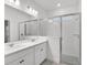 Modern bathroom featuring double sinks and glass-enclosed shower at 1988 Sunshine Peak Dr, Minneola, FL 34715