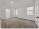 Bright, empty bedroom featuring neutral carpet, two windows, and an en-suite bathroom at 1988 Sunshine Peak Dr, Minneola, FL 34715