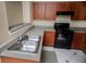 The kitchen features wood cabinets, ample counter space, a dual sink, and an electric range at 206 E South St # 4031, Orlando, FL 32801