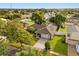 An aerial view of a single-story home with a brick driveway in a tree-lined neighborhood at 211 S Deerwood Ave, Orlando, FL 32825