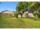 Grassy backyard featuring a patio and an archway covered in climbing plants at 211 S Deerwood Ave, Orlando, FL 32825