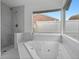 A luxurious soaking tub with a large window and a separate shower at 211 S Deerwood Ave, Orlando, FL 32825