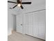 This bedroom features a ceiling fan and a large closet with white louvered doors at 211 S Deerwood Ave, Orlando, FL 32825