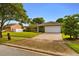 Charming single-story home with a well-manicured lawn and a brick-paved driveway at 211 S Deerwood Ave, Orlando, FL 32825