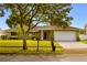 Inviting single-story home featuring a lush green lawn and a classic front entrance at 211 S Deerwood Ave, Orlando, FL 32825