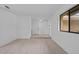 Open living space with light wood floors, freshly painted white walls, and a window view at 211 S Deerwood Ave, Orlando, FL 32825