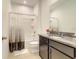 Bathroom featuring a granite countertop, decorative mirror, and shower-tub combo at 2182 Cooper Bell Pl, Kissimmee, FL 34747