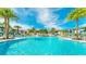 Lagoon-style community pool surrounded by palm trees, umbrellas and lounge chairs at 2182 Cooper Bell Pl, Kissimmee, FL 34747