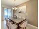 Well-lit dining room features a modern chandelier, neutral tones, and sliding glass doors to a patio at 2182 Cooper Bell Pl, Kissimmee, FL 34747