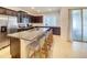 Modern kitchen featuring dark cabinets, stainless steel appliances, a large island, and bar stool seating at 2182 Cooper Bell Pl, Kissimmee, FL 34747