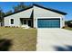 Inviting single-story home featuring modern architecture, tidy landscaping, and a striking blue garage door at 2249 Sw 146 Loop, Ocala, FL 34473