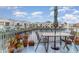 Relaxing balcony view with table and chairs overlooking waterfront and buildings against a blue sky at 2552 Woodgate Blvd # 204, Orlando, FL 32822