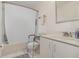 Bright bathroom featuring a shower-tub combo with safety bars and a white vanity at 2552 Woodgate Blvd # 204, Orlando, FL 32822