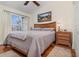 Comfortable bedroom with hardwood floors, soft lighting, a ceiling fan, and a serene window view at 2552 Woodgate Blvd # 204, Orlando, FL 32822