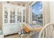 Cozy dining area with china cabinet, small table, and outdoor view through the window at 2552 Woodgate Blvd # 204, Orlando, FL 32822