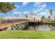 Waterfront property with a charming wood bridge leading to the house on stilts, surrounded by a canal at 2552 Woodgate Blvd # 204, Orlando, FL 32822