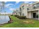 Exterior of townhouses along waterfront featuring balconies with blue railings and lush landscaping at 2552 Woodgate Blvd # 204, Orlando, FL 32822
