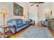 Bright living room with a blue velvet sofa, hardwood floors, tall ceilings and an impressive painting at 2552 Woodgate Blvd # 204, Orlando, FL 32822