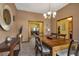 Formal dining room featuring a wooden table, six chairs, modern chandelier, and views into other living spaces at 2825 Lake Tohopekaliga Blvd, Kissimmee, FL 34746