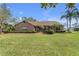 Inviting brick home featuring a well-manicured lawn and mature landscaping, creating a warm curb appeal at 2825 Lake Tohopekaliga Blvd, Kissimmee, FL 34746