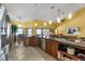 Bright kitchen featuring tile floors, stainless appliances, wooden cabinetry, and an adjacent dining area and living room at 2825 Lake Tohopekaliga Blvd, Kissimmee, FL 34746