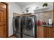 Bright laundry room with dual stainless steel washer and dryer and granite counters at 2825 Lake Tohopekaliga Blvd, Kissimmee, FL 34746