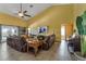 A sunlit living room with a ceiling fan, tile flooring, leather sofas, and a partial view of the swimming pool at 2825 Lake Tohopekaliga Blvd, Kissimmee, FL 34746