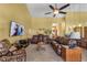 A comfortable living room with brown leather couches, tile floors, and a ceiling fan for a relaxed ambiance at 2825 Lake Tohopekaliga Blvd, Kissimmee, FL 34746