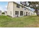 The backyard shows a multi-story tan townhome, a grassy yard, and some Spanish moss hanging from trees at 3167 Crown Jewel Ct, Winter Park, FL 32792