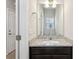 The half bathroom features a dark wood vanity, granite countertop, modern fixtures, and ample lighting at 3167 Crown Jewel Ct, Winter Park, FL 32792