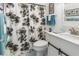 Well-lit bathroom featuring a floral shower curtain, blue accent towels, a vanity and tiled floor at 325 Wilder Blvd # A404, Daytona Beach, FL 32114