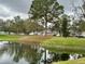 Scenic pond surrounded by lush greenery, mature trees and benches at 4154 Pinebark Ave # 3, Orlando, FL 32811