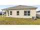 Back exterior view of house with lawn and covered patio, highlighting the home's architectural features at 5593 Vigo Loop, St Cloud, FL 34771