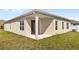 Back exterior view of house showcasing a covered patio area and well-maintained lawn at 5593 Vigo Loop, St Cloud, FL 34771