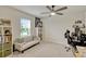 Bright, carpeted bedroom with a light gray sofa, desk, ceiling fan and ample natural light from a window at 5663 Keaton Springs Dr, Lakeland, FL 33811