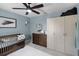 Charming Bedroom with blue walls, complemented by a wooden crib, dresser, and ample storage space at 5663 Keaton Springs Dr, Lakeland, FL 33811