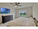 Cozy bedroom features a large bed, ceiling fan, and dresser with a backyard view at 5663 Keaton Springs Dr, Lakeland, FL 33811