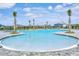 Large community pool with zero entry, palm trees, dark fencing and several houses in the background at 5663 Keaton Springs Dr, Lakeland, FL 33811