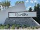 Stone sign with Riverstone name in dark brown lettering is partially surrounded by green foliage at 5663 Keaton Springs Dr, Lakeland, FL 33811